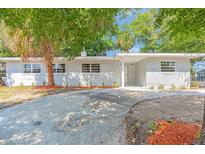 Charming single-story home featuring a gray exterior, well-manicured landscaping, and a spacious concrete driveway at 2711 E 22Nd Ave, Tampa, FL 33605