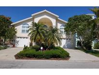 Two-story home with a well-manicured lawn, palm trees and a large driveway leading to two garages at 5025 Westshore Dr, New Port Richey, FL 34652