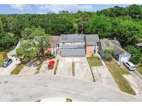 Aerial view of townhomes with mature trees, driveways, and a vibrant tree canopy backdrop at 9473 N Forest Hills Pl, Tampa, FL 33612