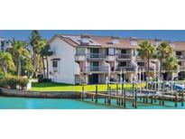 Waterfront condo featuring a private dock, balconies, and lush landscaping, perfect for enjoying coastal living at 101 Marina Del Rey Ct, Clearwater, FL 33767