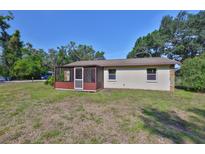 Cozy home featuring a screened-in porch and ample yard space, perfect for outdoor enjoyment at 1019 Lakeside Dr, Seffner, FL 33584