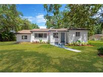 Charming white brick home with a well-manicured front yard and beautiful landscaping at 1128 S 70Th St, Tampa, FL 33619