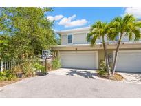 Two-story home featuring a two-car garage, verdant landscaping, and a basketball hoop in the driveway at 1271 Drew St, Clearwater, FL 33755