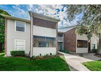 View of multi-story condo complex with screened-in patios, grey siding, brick accents, and mature landscaping at 1400 Gandy N Blvd # 1705, St Petersburg, FL 33702