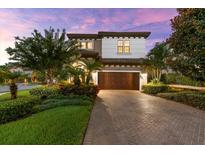 Stunning two-story home with a paver driveway and lush landscaping at 1570 Marinella Dr, Palm Harbor, FL 34683