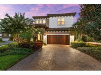 Beautiful two-story home featuring a paver driveway and meticulously maintained landscaping at 1570 Marinella Dr, Palm Harbor, FL 34683