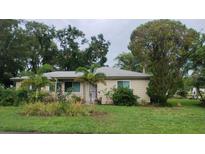 Charming single-story home with well-kept lawn, palm trees, and lush landscaping at 1735 Cleveland St, Clearwater, FL 33755