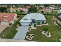 Beautiful single-story home with manicured lawn, stone landscaping, and a white tile roof at 2252 New Bedford Dr, Sun City Center, FL 33573