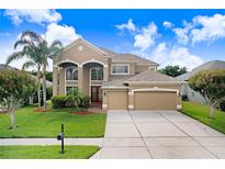 Stunning two-story home featuring a manicured lawn, mature trees, and a convenient two-car garage at 23325 Abercorn Ln, Land O Lakes, FL 34639