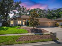 Beautiful single-story home featuring a well-manicured lawn, mature landscaping, and a charming facade at 2903 Manor Ridge Pl, Valrico, FL 33596
