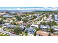 Expansive aerial view of waterfront neighborhood with canals, marina, and single Gathering homes under a sunny, blue sky at 4710 Travertine Dr, Tampa, FL 33615