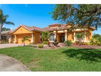 Stunning single Gathering home features a meticulously landscaped front yard, terracotta roof, and charming water fountain feature at 800 Belted Kingfisher S Dr, Palm Harbor, FL 34683