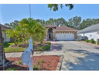 Charming single-Gathering home boasts a well-manicured lawn, mature landscaping, and a two-car garage at 8916 Southbay Dr, Tampa, FL 33615