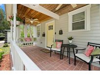 Inviting front porch with swing, seating, and classic brick flooring at 1003 W Indiana Ave, Tampa, FL 33603