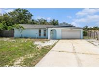 Charming single-Gathering home featuring a two-car garage, a light blue exterior, and a well-maintained front yard at 12019 106Th Ct, Largo, FL 33778
