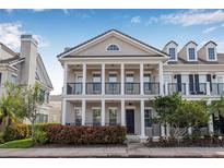 Charming two-story townhome featuring a covered porch with white columns and a well-maintained landscaped front yard at 135 Commonwealth N Ct, St Petersburg, FL 33716