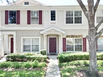 Charming townhouse with landscaped front yard, featuring colorful shutters and a welcoming entrance at 15922 Fishhawk Creek Ln, Lithia, FL 33547