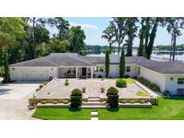 Beautiful single-story home with lush landscaping, brick-paved entry, and stunning lake views at 16315 Lonely Ln, Odessa, FL 33556