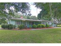 Charming single-story home featuring a well-maintained lawn, mature landscaping, and a cozy covered porch at 3020 N Maryland Ave, Plant City, FL 33563