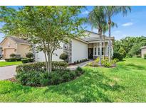 Beautifully landscaped single-story home with stone accents and a well-manicured lawn at 30410 Ceasar Park Dr, Wesley Chapel, FL 33543