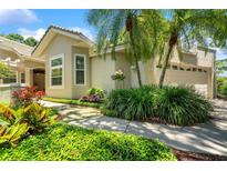 Charming single-Gathering home with mature landscaping, stone walkway, and attached two-car garage at 423 Fan Palm Ne Ct, St Petersburg, FL 33703