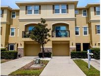 A three-story townhouse featuring dual garages, windows, and a second-story balcony at 5529 White Marlin Ct, New Port Richey, FL 34652