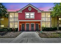 Charming two-story condo with a colorful red exterior, screened-in balconies, and well-maintained landscaping at 5705 Baywater Dr # 5705, Tampa, FL 33615