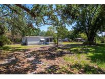 Charming home featuring a screened-in porch and a spacious yard with mature trees at 6226 Florence St, Gibsonton, FL 33534