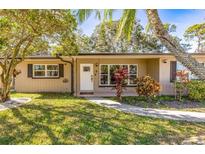 Inviting single-story home with a lush green lawn and mature trees at 7137 Wedgewood Dr, New Port Richey, FL 34652