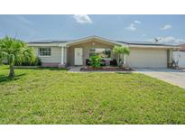 Charming single-story home with a well-maintained lawn, inviting front porch, and mature landscaping at 1118 Lodestar Dr, Holiday, FL 34690