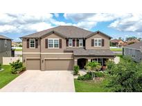Charming two-story home featuring a three-car garage, well-maintained landscaping, and a welcoming front porch at 13111 Bahia Grass Ln, Riverview, FL 33579