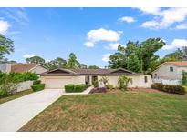 Charming single-story home with a well-manicured lawn and mature landscaping, complete with a two-car garage at 14175 Feather Sound Dr, Clearwater, FL 33762