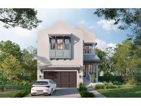 Charming two-story home with a stucco facade, a two-car garage, and professionally landscaped front yard at 143 Chesapeake Ave, Tampa, FL 33606