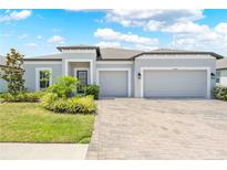 Charming single-story home featuring a three-car garage and beautiful front yard landscaping at 17618 Cortes Creek Blvd, Spring Hill, FL 34610