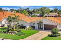 Stunning single-story home with a red tile roof, beautiful landscaping, and a brick driveway at 1901 Kansas Ne Ave, St Petersburg, FL 33703