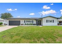 Charming single-story home featuring a well-maintained lawn and a two-car garage at 2132 Academy Dr, Clearwater, FL 33764
