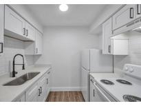Bright kitchen features white cabinets, subway tile backsplash, modern countertops, and stainless steel sink at 2353 Shelley St # 6, Clearwater, FL 33765