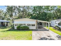 Charming single-story home featuring a covered carport and well-maintained front lawn at 3542 Castle Dr, Zephyrhills, FL 33540