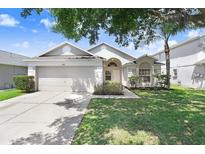 Well-maintained one-story home features a two-car garage and lush landscaping at 4921 Wessex Way, Land O Lakes, FL 34638