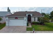 Charming single-story home with a brick driveway, two-car garage, and well-maintained landscaping at 550 Salmon Ct, Oldsmar, FL 34677