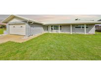 Charming single-story home featuring a well-manicured lawn and attached two-car garage with a white roof at 710 116Th Ave, Treasure Island, FL 33706