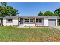 Charming one story home featuring a covered entry and an attached one car garage at 7500 16Th N St, St Petersburg, FL 33702