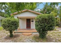 Charming single-story home featuring a brick porch and neatly trimmed shrubbery in the front yard at 7511 N Ola Ave, Tampa, FL 33604