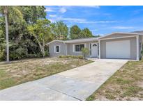 Charming single-story home with a well-maintained lawn and a driveway leading to an attached garage at 106 Avery Ave, Crystal Beach, FL 34681