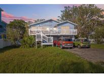 Charming two-story home with a spacious front deck and well-maintained yard with parking for multiple cars at 108 Shore Dr, Tarpon Springs, FL 34689