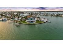 Waterfront home boasts a private pool, lush landscaping and picturesque waterfront views at sunset at 11000 8Th E St, Treasure Island, FL 33706
