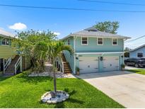 Charming two-story home with a well-manicured lawn and two-car garage at 14409 Birch St, Hudson, FL 34667