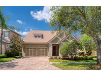 Beautiful single-Gathering home featuring a well-maintained lawn, brick driveway, and a two-car garage at 14610 Mondavi Ct, Tampa, FL 33626