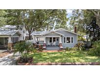 Charming single Gathering home with a covered porch and manicured lawn and beautiful landscaping at 212 W Powhatan Ave, Tampa, FL 33604