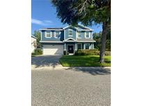 Charming two-story blue home with a well-maintained front yard and a two car garage at 2325 Via Bella Blvd, Land O Lakes, FL 34639